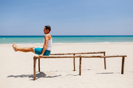 fitness handsome man work out on the beach with sea viewの写真素材