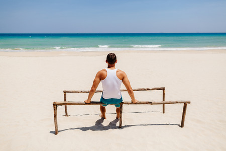 fitness handsome man work out on the beach with sea viewの写真素材