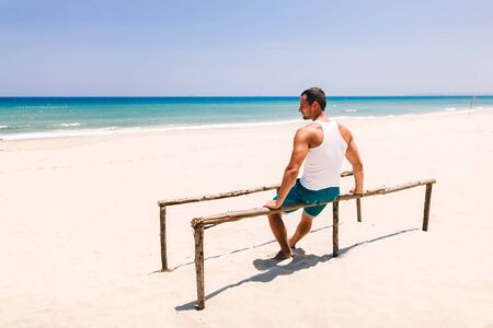 fitness man relax on the beach back viewの写真素材