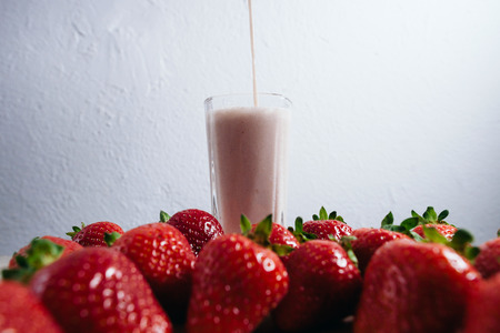 strawberry smoothie milkshake fresh blended with fresh strawberry on summer wood tableの写真素材