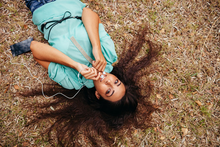 girl listening to music on smartphone aerial top view