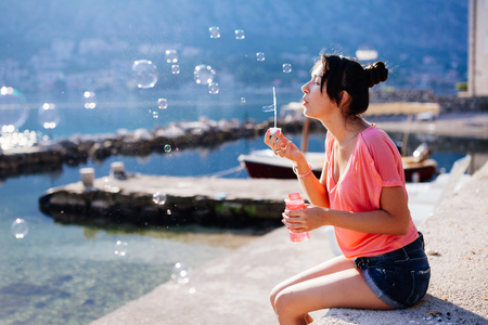 girl blow bubbles on beach