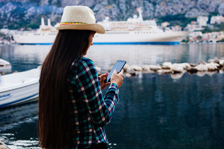 girl travel and search in smartphone on pier beach bay water cruise liner backgroundの写真素材