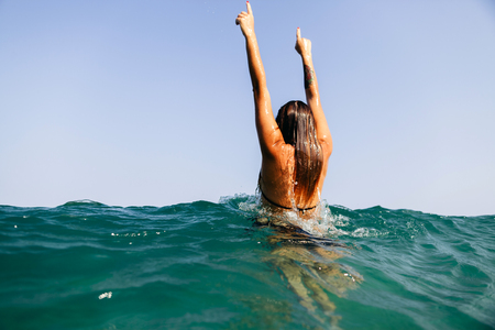 sexy bikini girl in sea, hands upの写真素材