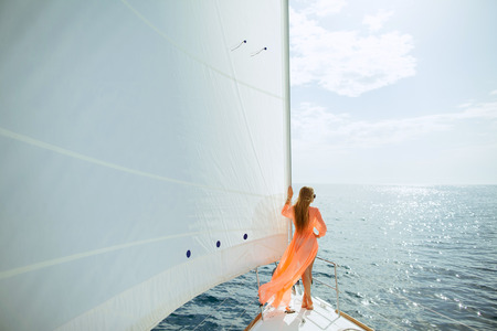 woman in sarong yachting white sails cruise luxury travel vacationの写真素材
