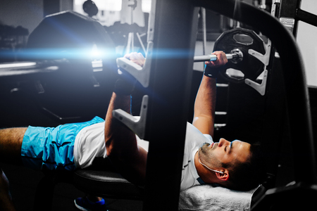 handsome fitness man weightlifting in gym with happy face
