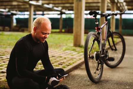 bicycle man searching in smartphone at parkingの写真素材