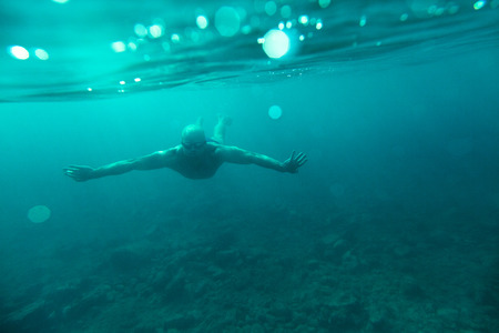 man swim underwater sea diveの写真素材