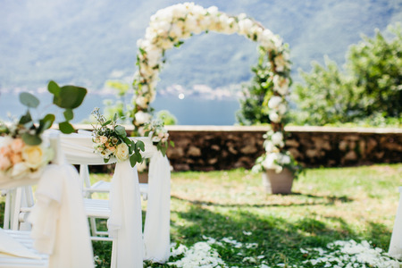 wedding chair cover with flowers decoration and destination wedding arch backgroundの写真素材