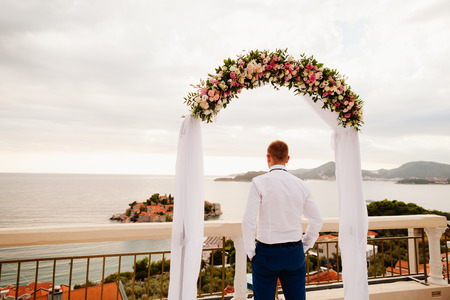 destination wedding groom at sunset with sea view. Back viewの写真素材
