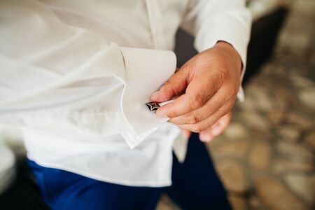 groom wear cufflink close up shot with sea viewの写真素材