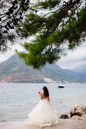 unidentified bride walking in picturesque bay with mountains view. Luxury bride in Montenegroの写真素材