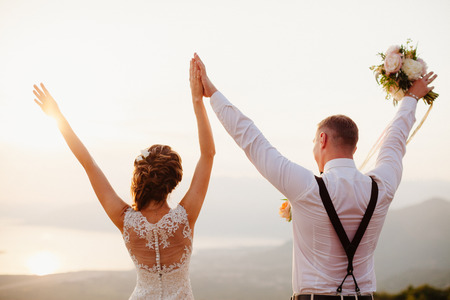 honeymoon wedding couple travel back view. Sunset in mountainsの写真素材