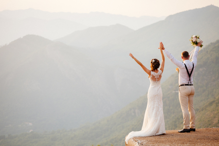honeymoon wedding couple travel back view. Sunset in mountainsの写真素材