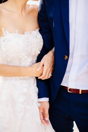 bride and groom holding hands together. Close up. Fine art styleの写真素材