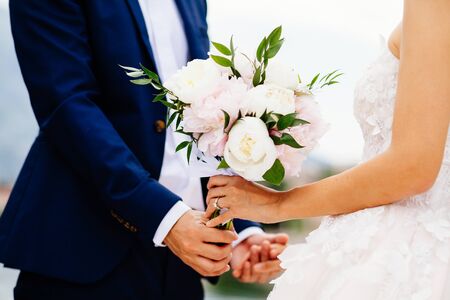 bride and groom holding wedding bouquet together. Close up shotの写真素材