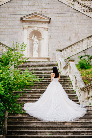 bride in wedding dress with church background. Back view. Destination weddingの写真素材