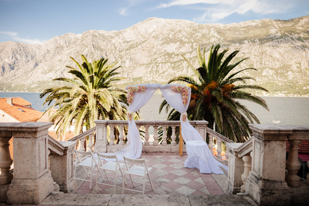 destination wedding arch with sea view and mountains at sunsetの写真素材