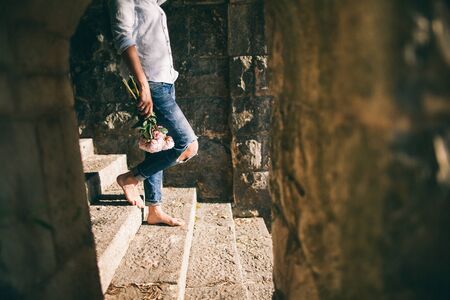 barefooted woman walk with flowers. Peony bouquetの写真素材