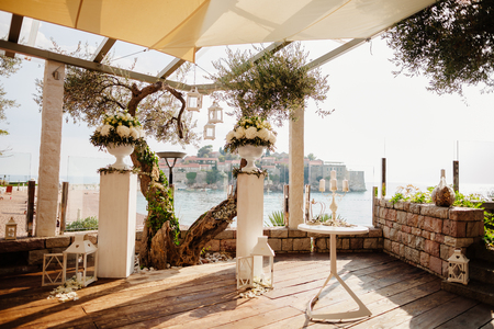 destination wedding ceremony arch with sea view and olives at sunsetの写真素材