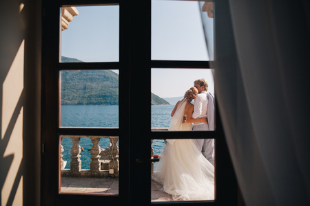 honeymoon wedding couple travel sea side. Back view. Mountains and sea background in Montenegroの写真素材
