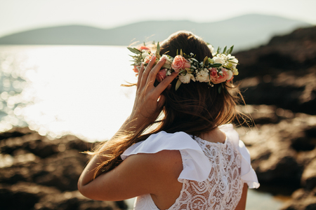 woman in bridal wreath on beach. Back view.の写真素材