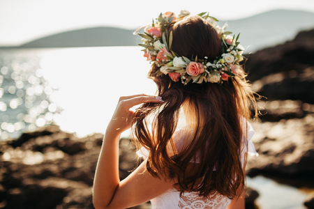 woman in bridal wreath on beach. Back view.の写真素材