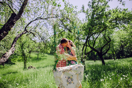 vintage love story couple. couple relax in green meadow and garden. Swing background.の写真素材