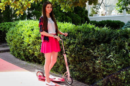 woman travelling by scooter. Happy sexy woman kick scootering at street. unfiltered.の写真素材