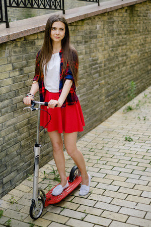 kick scootering girl. Happy girl kick scootering at street. unfiltered.の写真素材