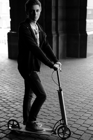 portrait of a boy on scooter in urban street. Black and white.の写真素材
