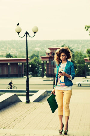 sexy fashion woman chat with smartphone. Woman walk down the street with phone.の写真素材