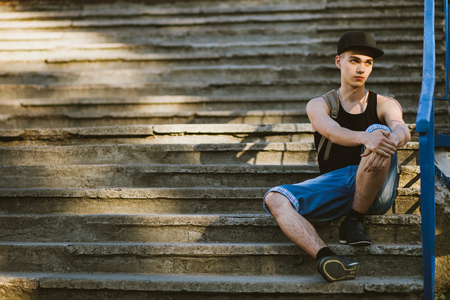 hip hop teenage man. Teenager walk on street in cap. Portrait of teenage hooligan man.の写真素材