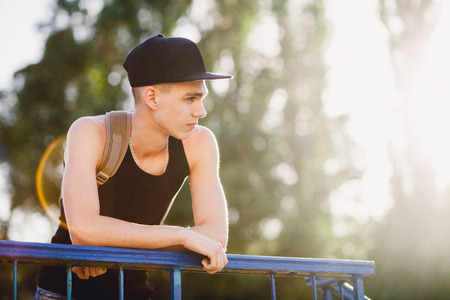 hip hop man walk on street. Teenager walk on street in cap. Portrait of teenage hooligan man.の写真素材