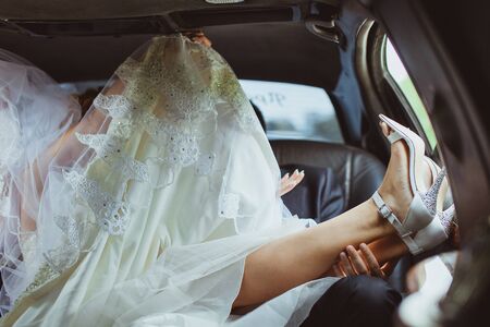 wedding couple in car. Couple drive on backseat of car.の写真素材
