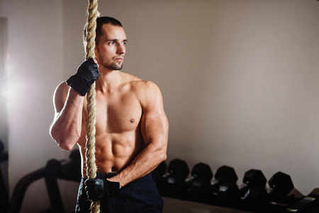rope climbing workout athlete man in gymの写真素材