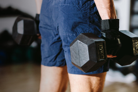 athletic male with dumbbells workout in gymの写真素材