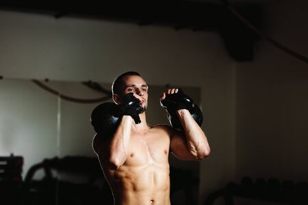 handsome athlete with Kettlebell workout in gym. Caucasian male athlete.の写真素材