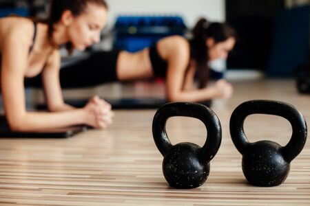 Fitness Girls Doing Plank yoga challenge in Gym. Fitness models plank work out.の写真素材