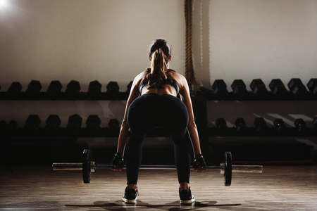 fitness woman weightlifting deadlift. Fitness model girl weightlifting in gym.の写真素材