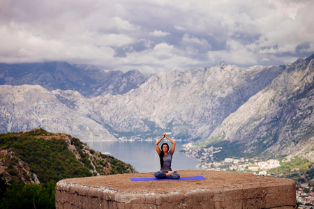 woman practicing yoga in mountains. Long hair woman yoga practice in the morning.の写真素材