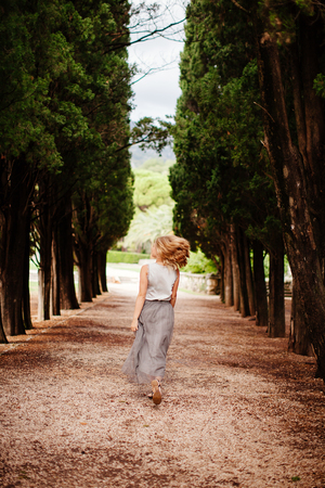 happy woman walk in forest. Green pine Park in summer.の写真素材