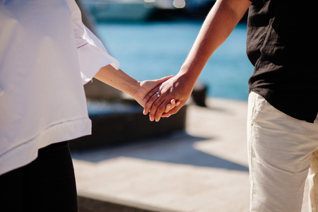 lovely couple holding hands at sunset. Close up shot.の写真素材