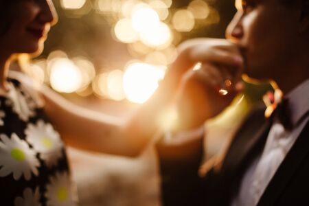man hand kissing woman. Tenderness. Sunset scenery. Out of focus.