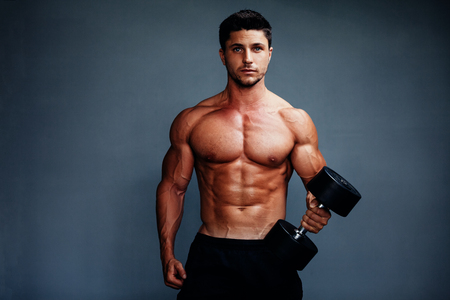 Handsome Muscular Bodybuilder Posing On Gray Backgroundの写真素材
