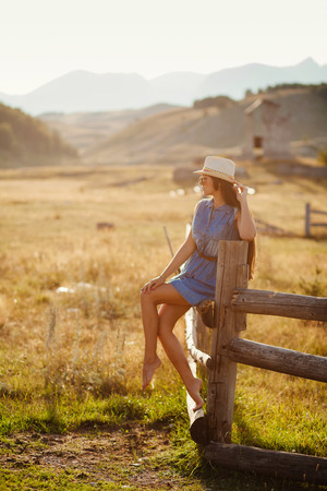 sexy woman travel countryside alone. Wooden houses and mountains background.の写真素材