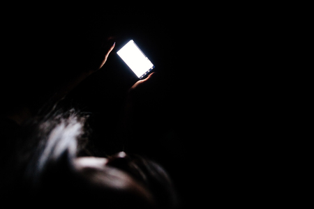 woman using smartphone at night. Smartphone mockup. POV view. Long hair woman.の写真素材