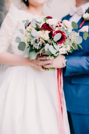bride and groom holding wedding bouquet. Fine art wedding bouquet. Tanging creamy bouquet wuth roses and peonies.の写真素材