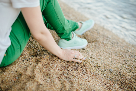 woman in green pants on beach. Relaxing on beach. back view. Montenegroの写真素材