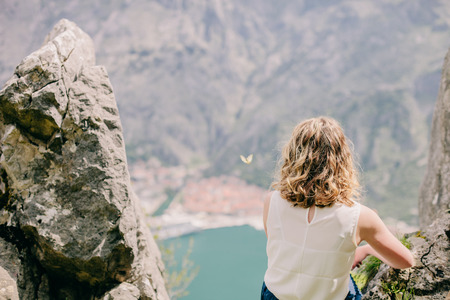 blonde girl travel in mountains back view. Kotor, Montenegroの写真素材